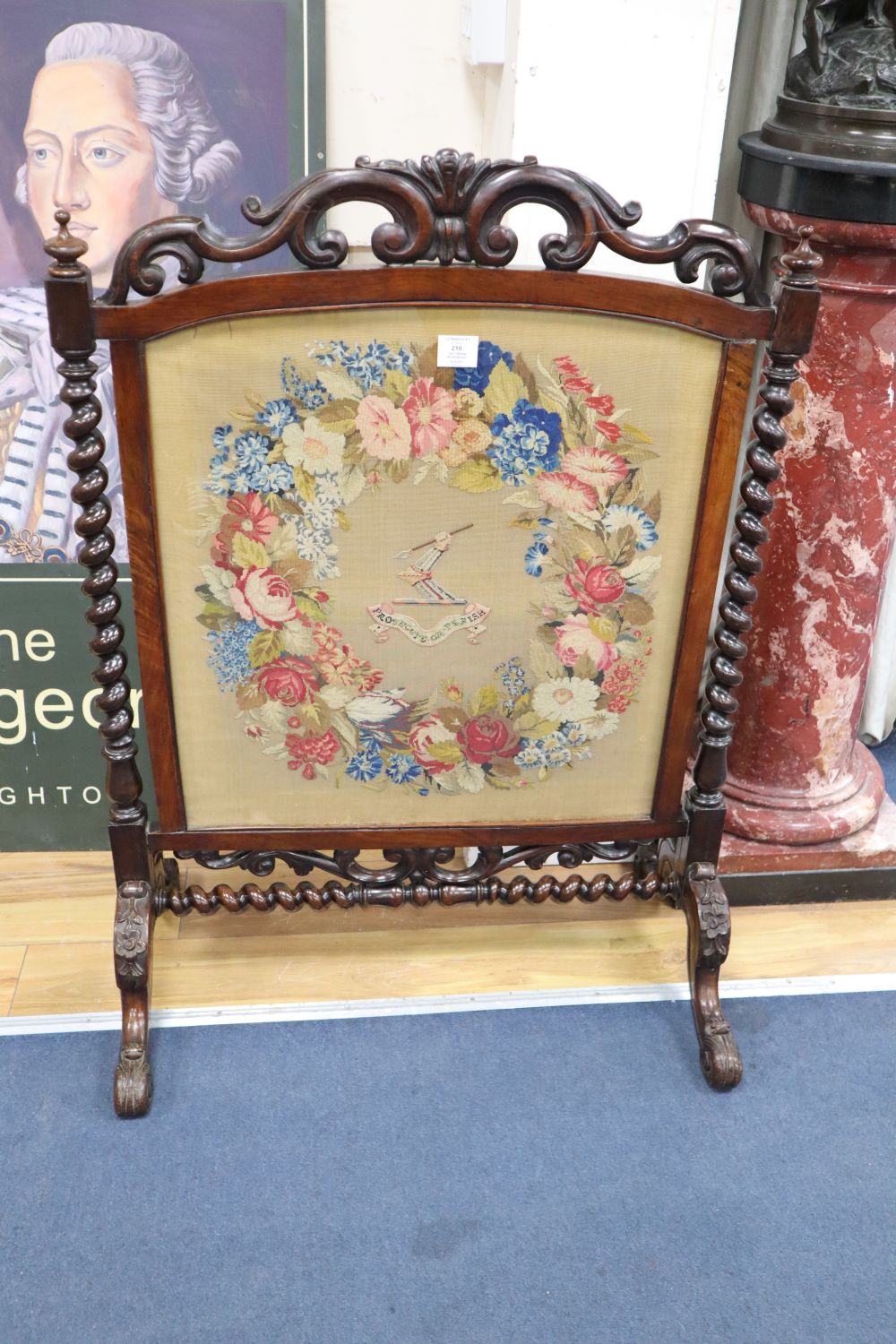 A Victorian rosewood firescreen with armorial tapestry banner, width 75cm, height 105cm